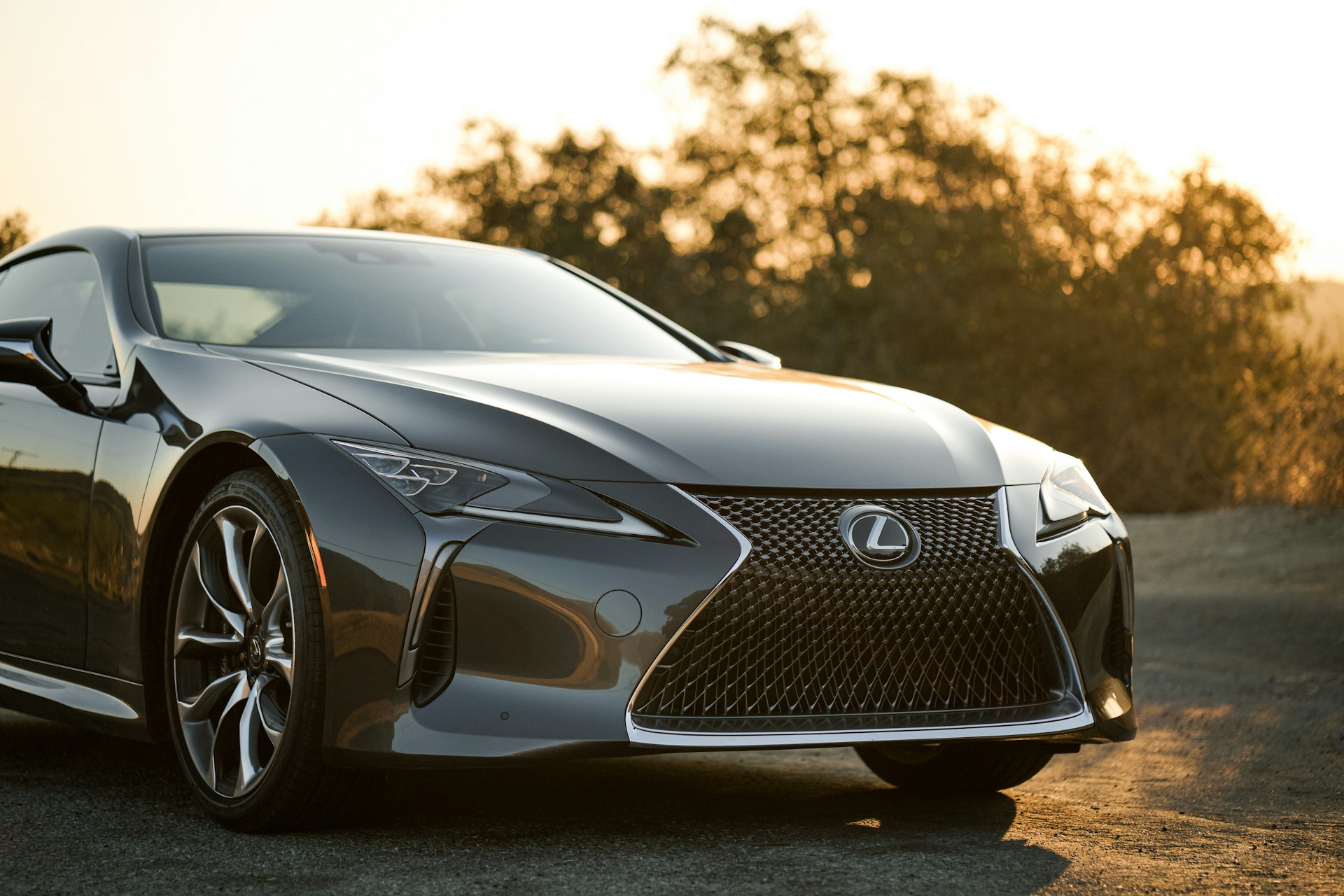 A black Lexus driving at sunset