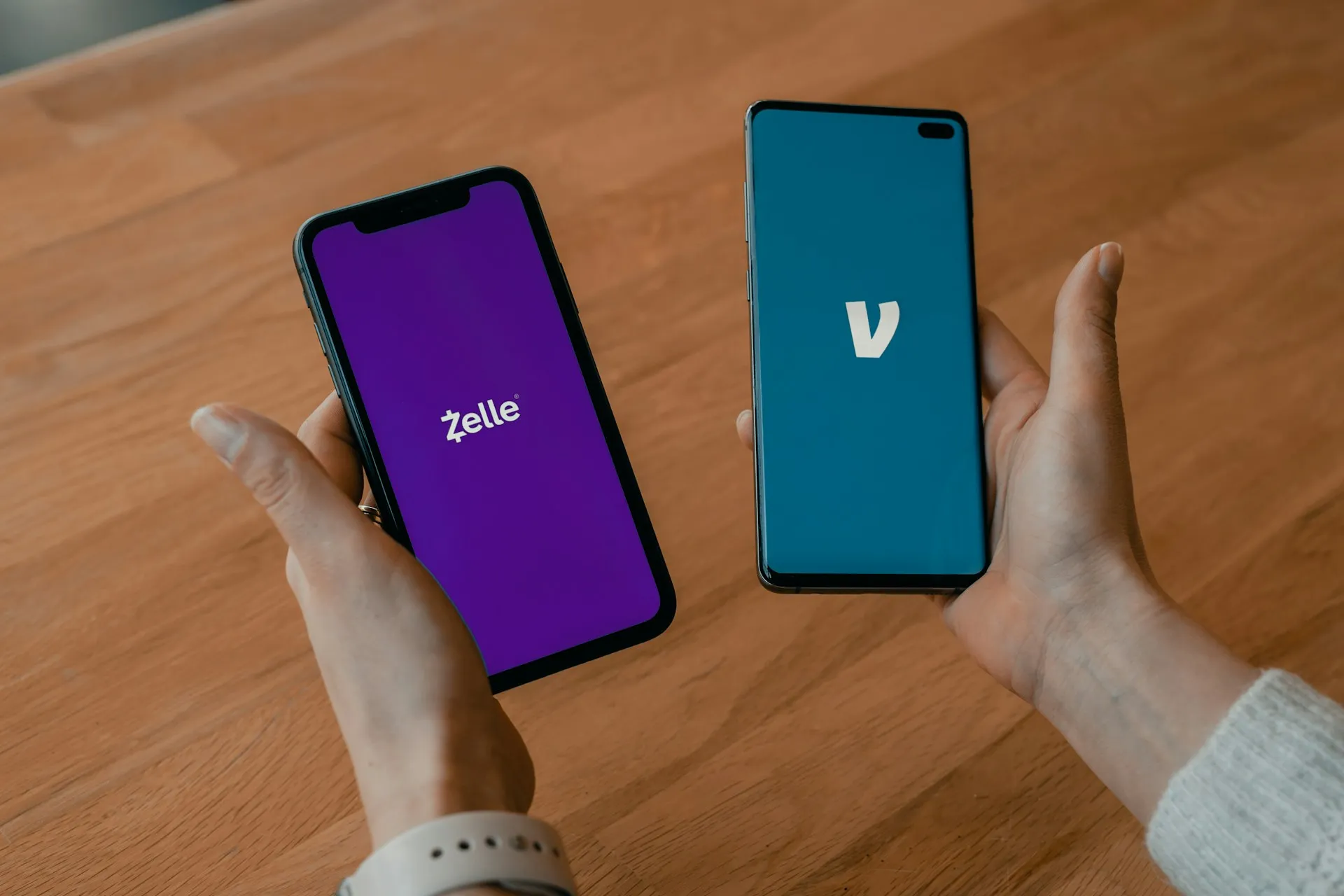 A person holding a phone with money transfer apps open