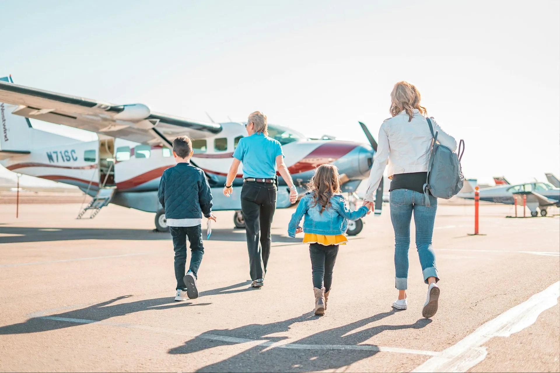 A family walking up to a small plane