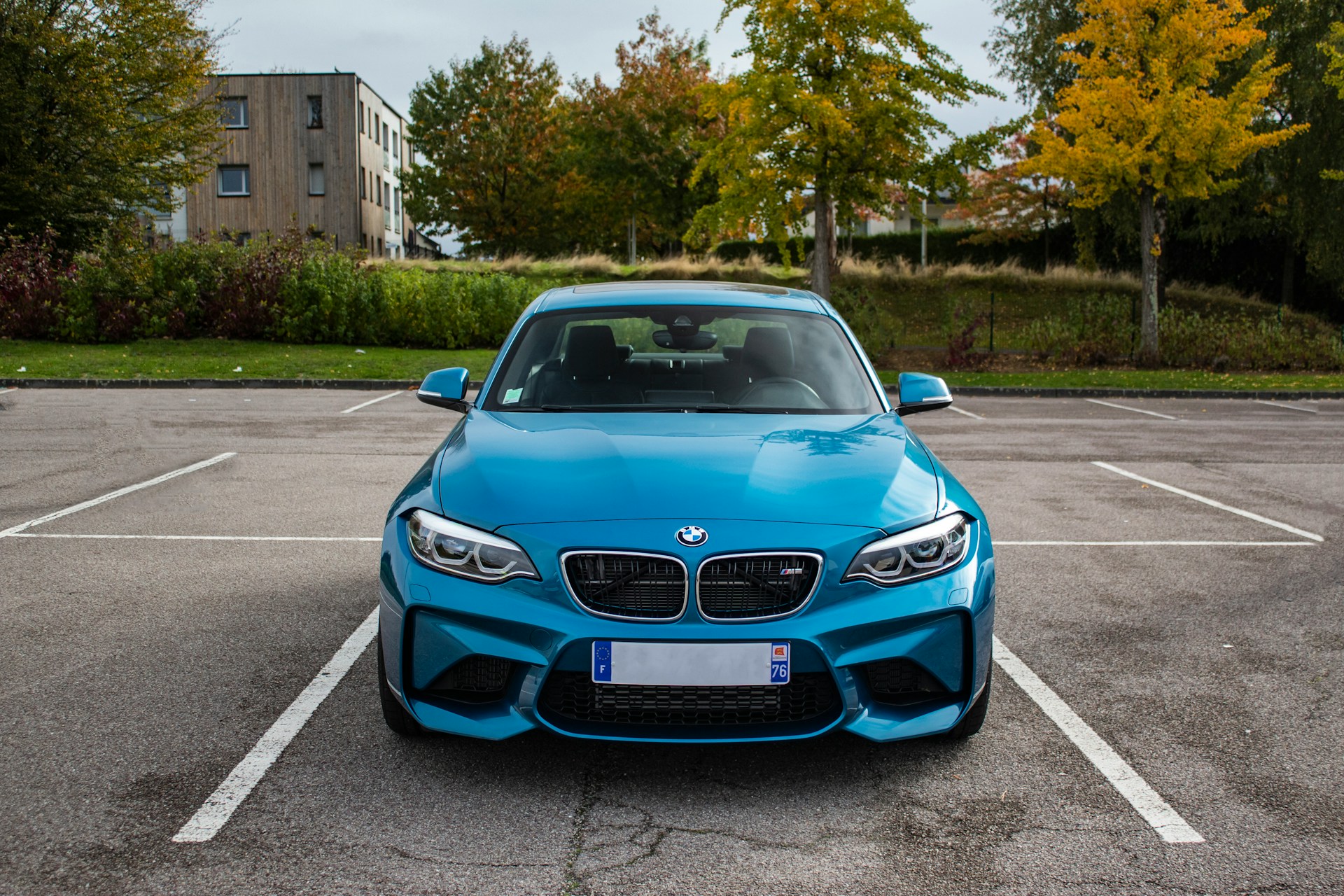 A blue BMW parked in a space